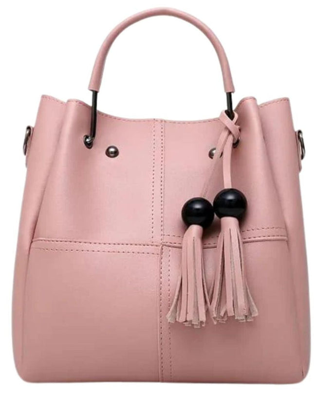 Pink handbag with black accents and tassels on a white background