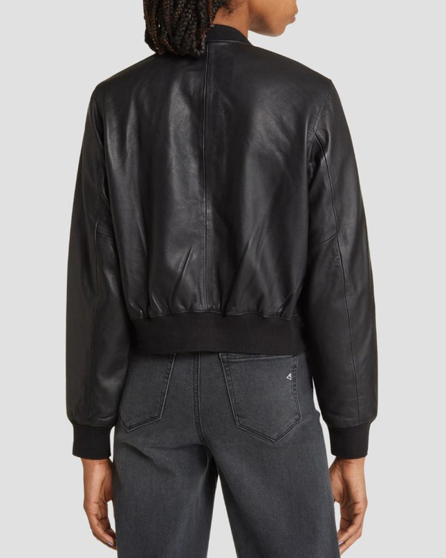 Person wearing a black leather bomber jacket on a light gray background