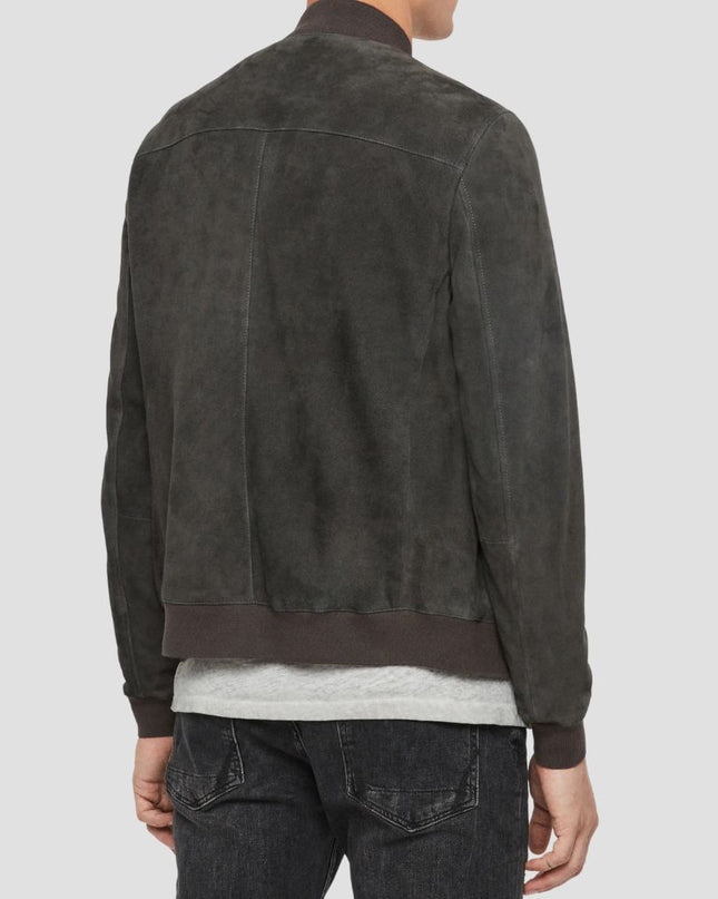 Person wearing a dark brown suede jacket on a light gray background