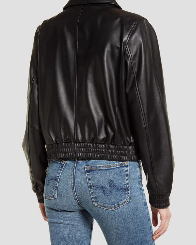 Person wearing a black leather jacket and blue jeans on a light gray background