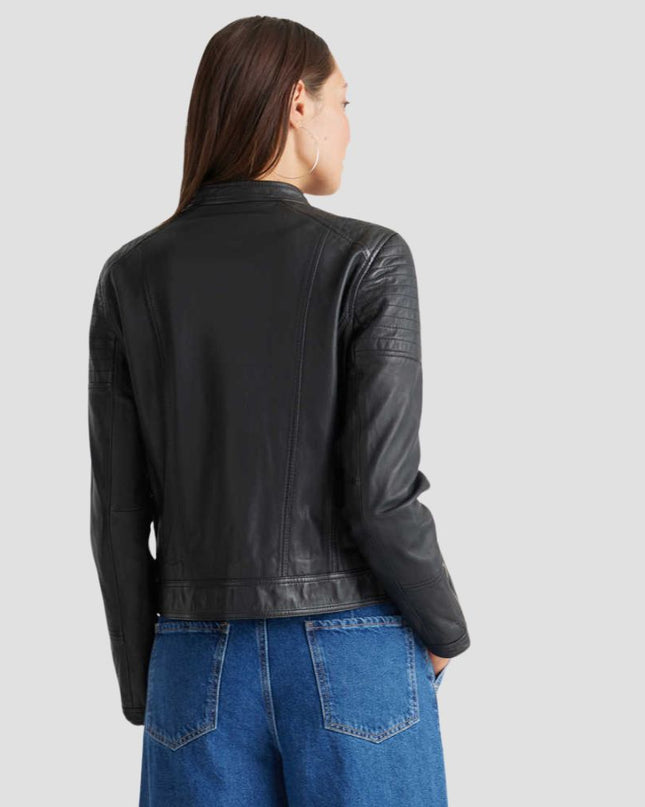 Person wearing a black leather jacket and blue jeans on a light gray background