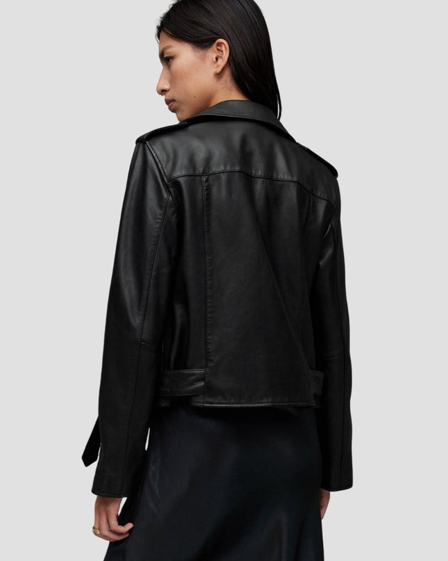 Person wearing a black leather jacket on a plain background