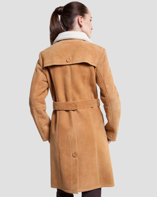 Woman wearing a tan coat on a light gray background