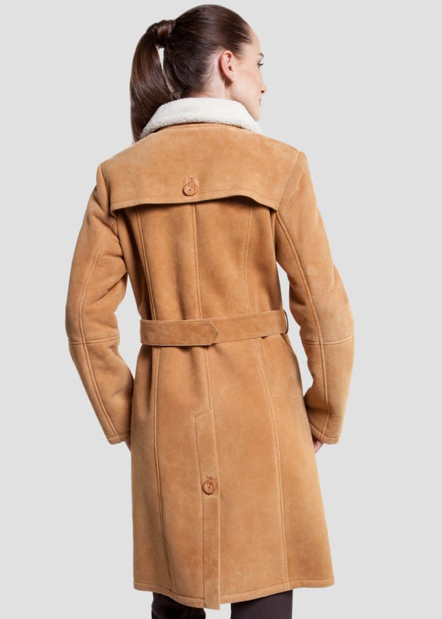 Woman wearing a tan coat on a light gray background
