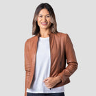 Woman wearing a brown leather jacket over a white shirt on a light gray background