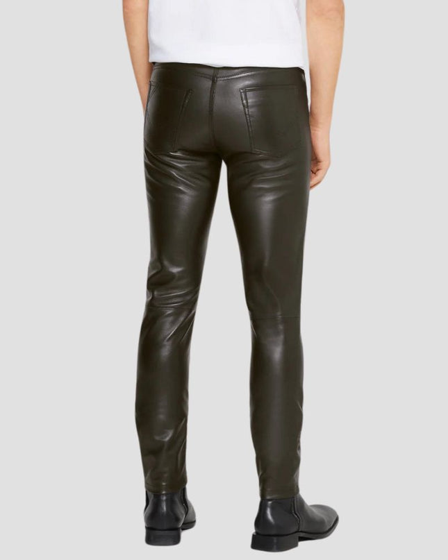 Person wearing dark leather pants on a plain background