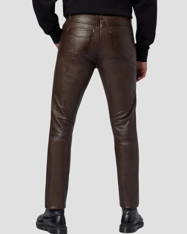 Brown leather pants worn by a person on a light gray background