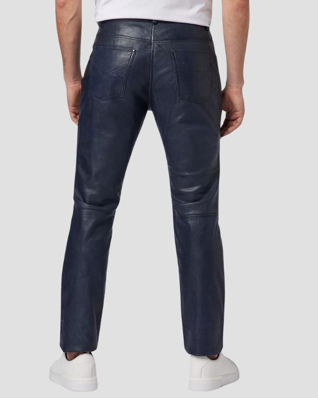 Person wearing dark blue leather pants on a light gray background