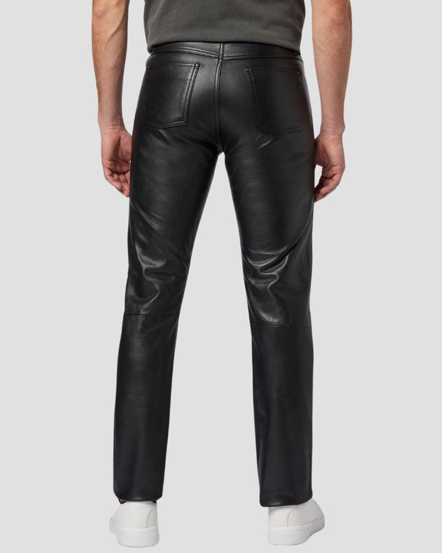 Person wearing black leather pants on a white background