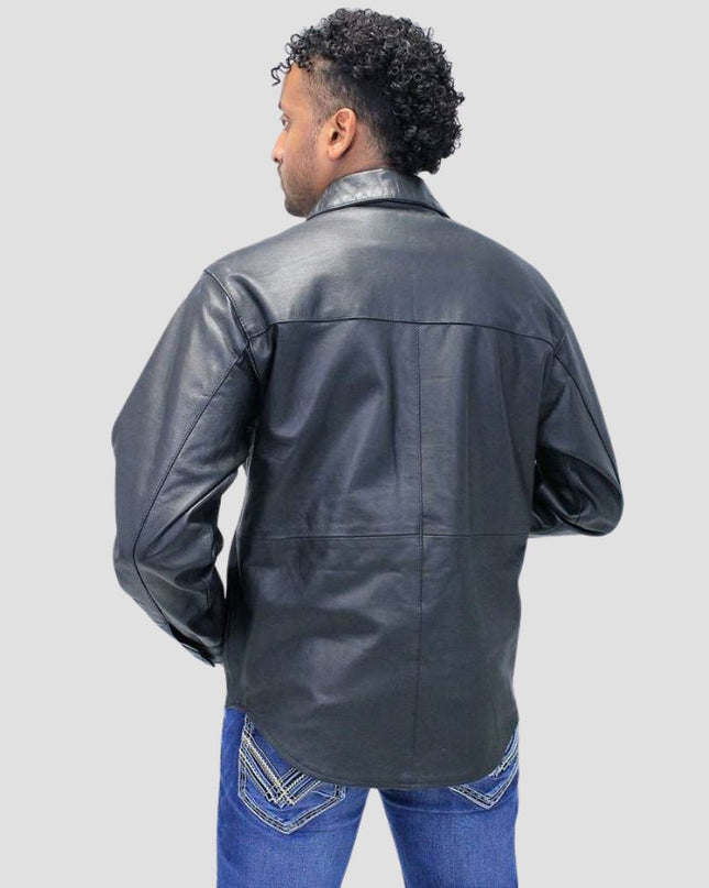 Person wearing a black leather jacket and blue jeans on a light gray background