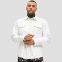 Man wearing a white shirt and green turtleneck against a plain background