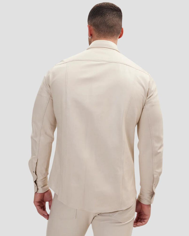 Man wearing a beige suit on a light gray background