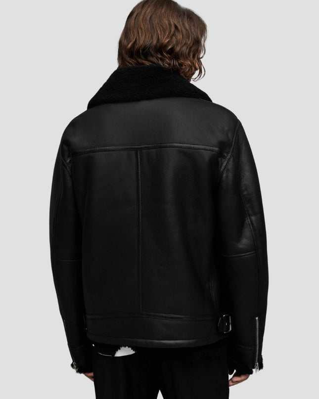 Person wearing a black leather jacket on a light gray background