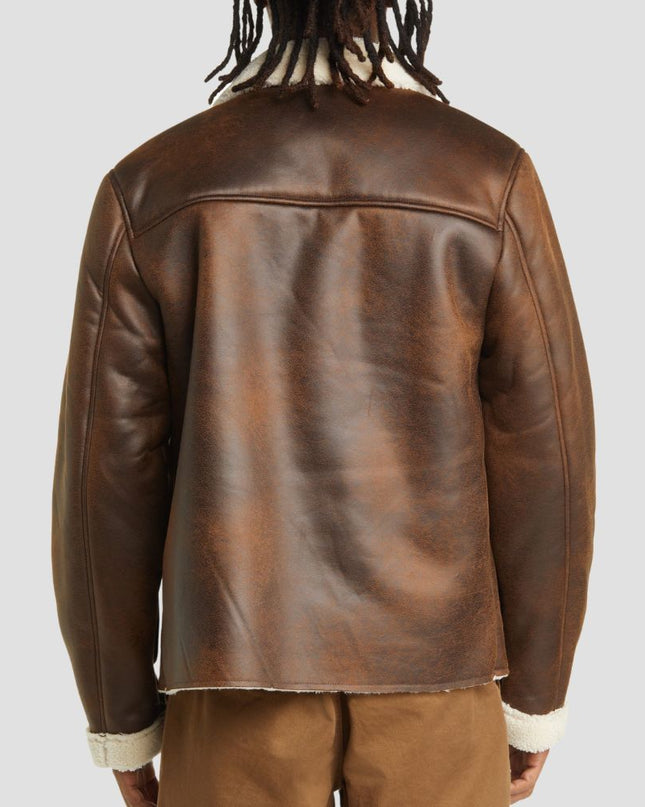 Brown leather jacket worn by a person on a light gray background