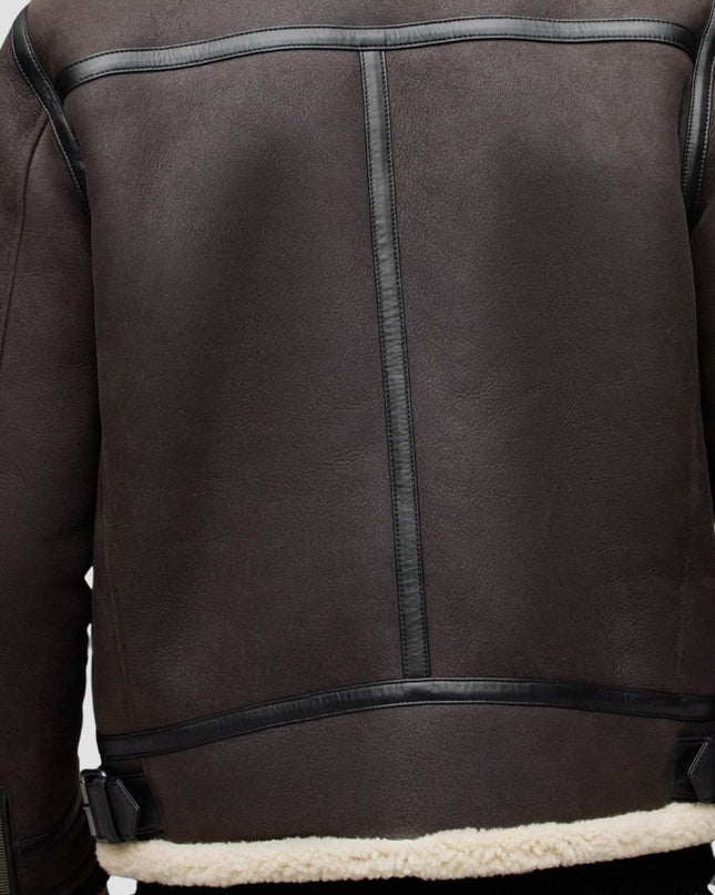 Brown leather jacket with black stitching on a white background