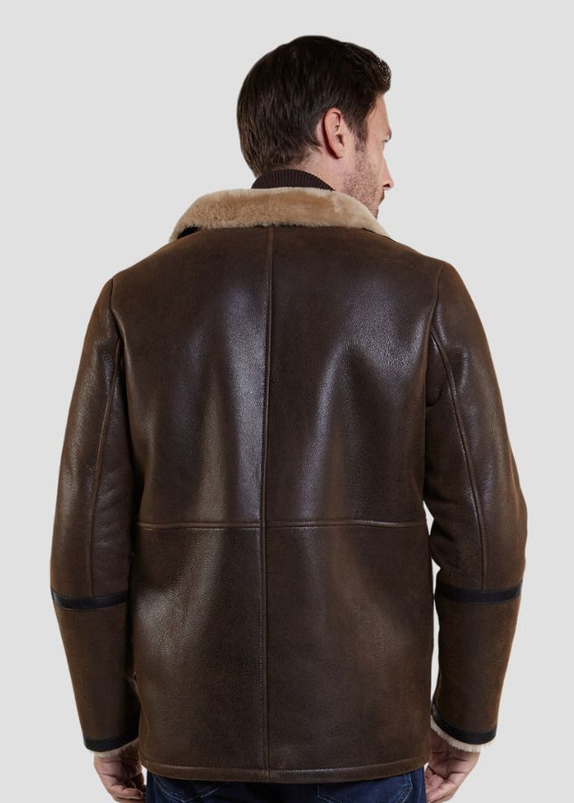Man wearing a brown leather jacket with fur collar on a light gray background