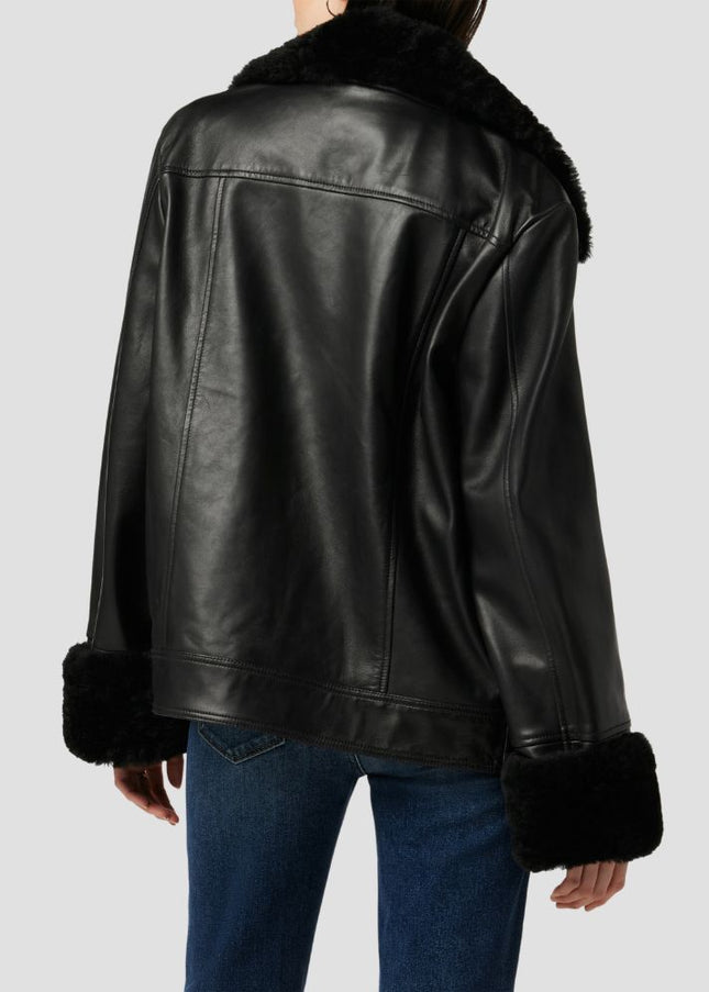 Black leather jacket with fur trim on a plain background