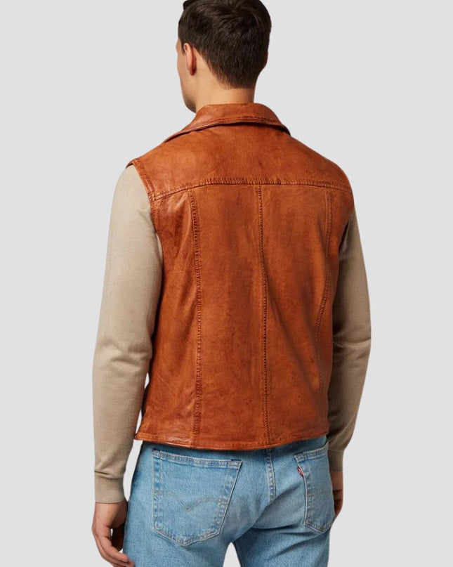 Man wearing a brown suede vest over a beige shirt and blue jeans on a light gray background