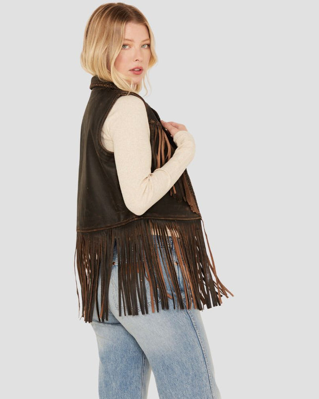 Woman wearing a brown fringed vest on a light gray background