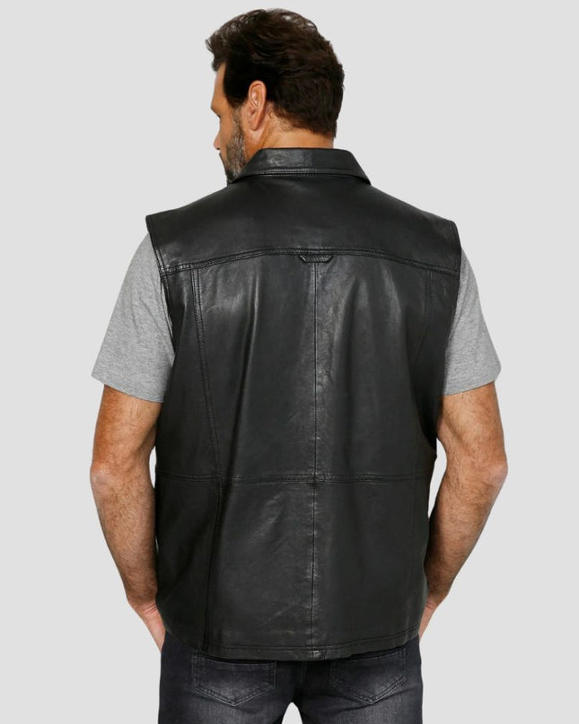 Man wearing a black leather vest on a gray background