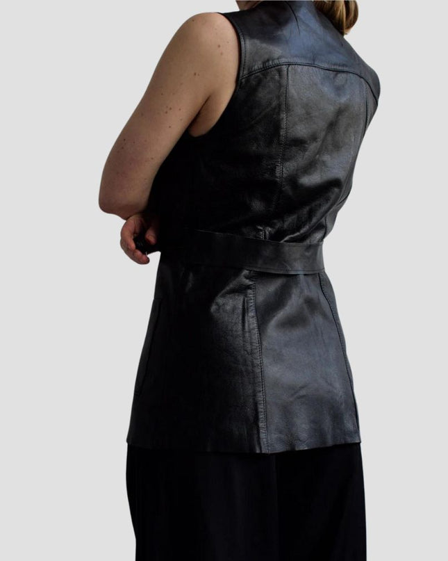 Person wearing a black leather vest on a plain background