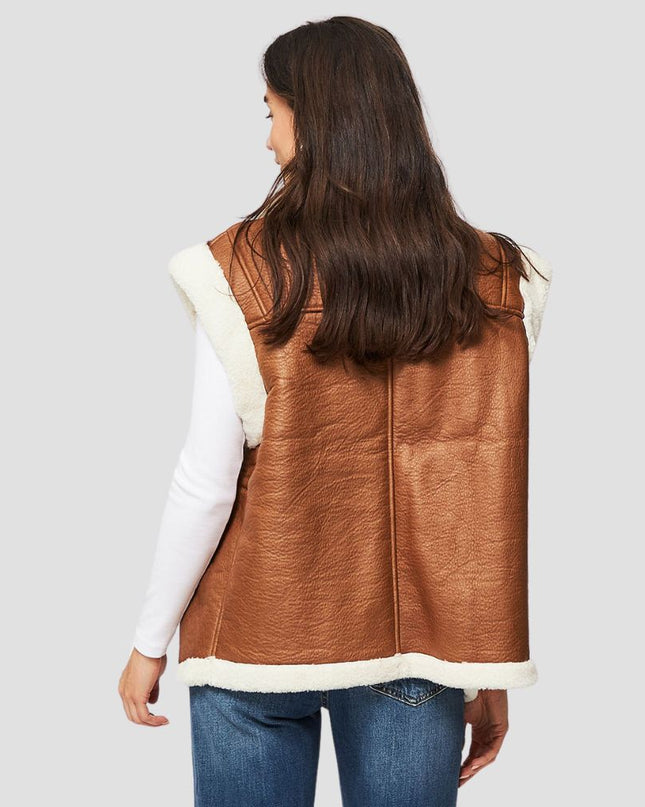 Person wearing a brown leather vest with white lining on a gray background