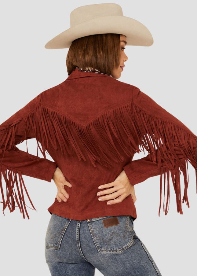Person wearing a red fringed jacket and beige cowboy hat on a light gray background
