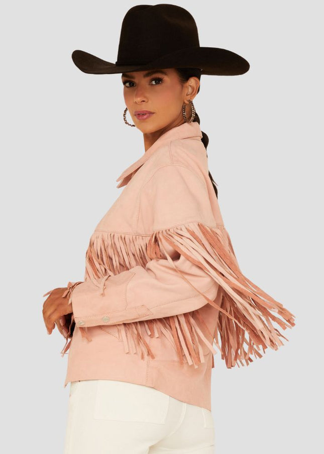 Woman wearing a pink fringed jacket and black cowboy hat on a light gray background