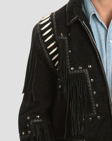 Black suede jacket with fringe and studs on a plain background