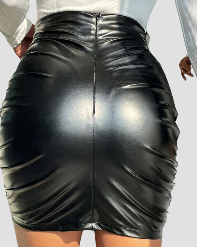 Black leather skirt worn by a person on a light gray background